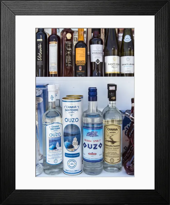 Framed Print : Bottles of traditional Ouzo liquor and local Greek wines on sale in a shop of Oia