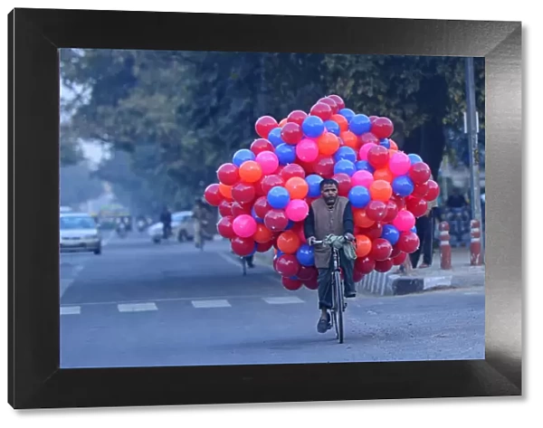 Street Vendor carrying balloons on the back of his bicycle, Delhi, National Capital