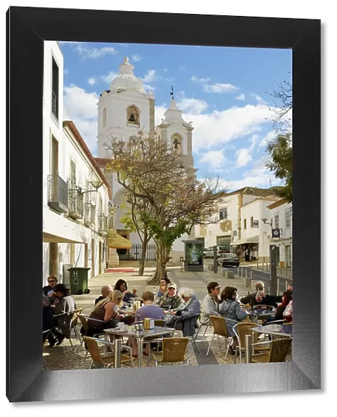 Tourists at a cafe and the church of Santo Antonio. Lagos Portugal