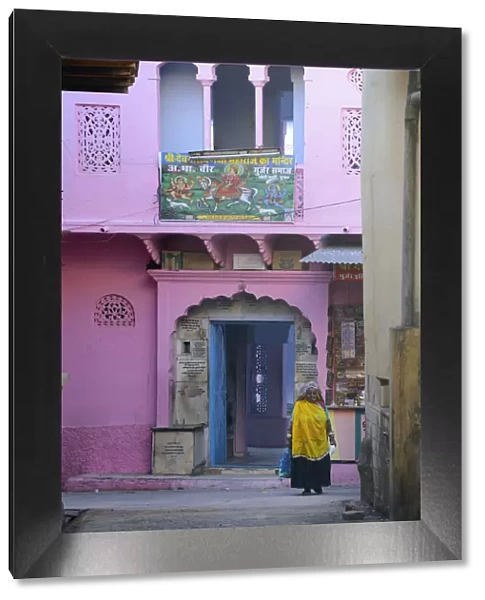 Woman walkin in front of colourful house, Pushkar, India, Asia