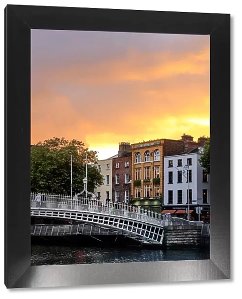 Northern Europe; Dublin, Halfpenny bridge and Liffey river at sunset