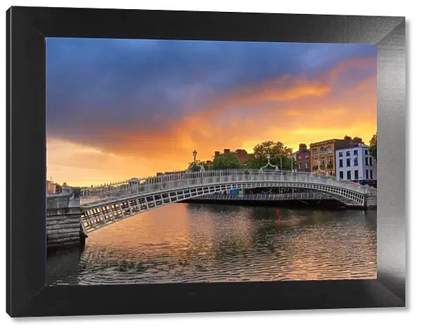Northern Europe; Dublin, Halfpenny bridge and Liffey river at sunset