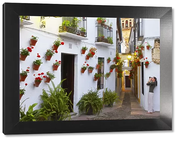 Spain, Andalucia, Cordoba, Woman photographing Traditional flower square (MR)