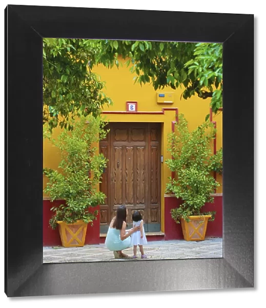 Spain, Andalucia, Seville, Woman and child infront of traditional doorway (MR)