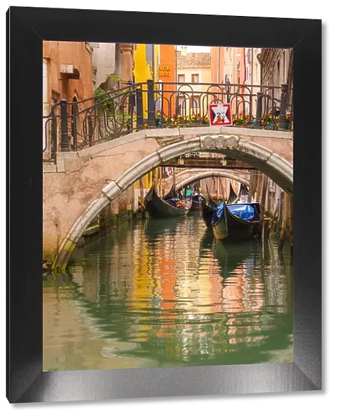 Venice, Veneto, Italy. Bridges and gondolas moored in a canal
