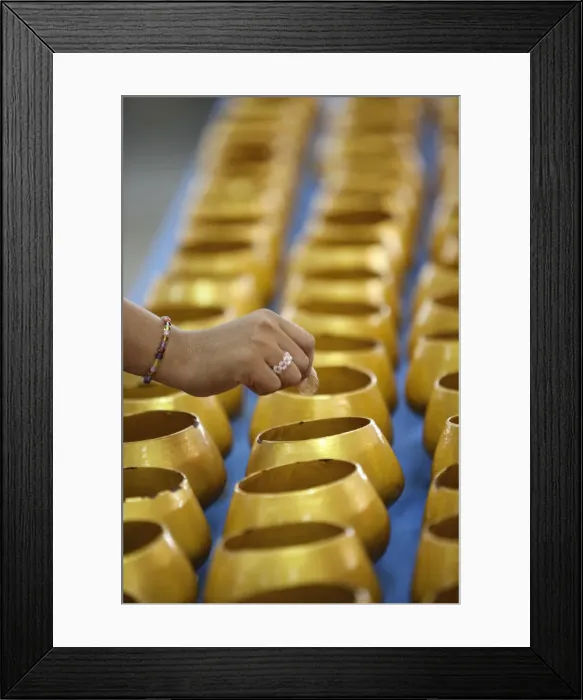 Framed Print : Bangkok, Thailand. A hand dropping a coin into an alms bowl on a altar in a buddhist Framed Print : Bangkok, Thailand. A hand dropping a coin into an alms bowl on a altar in a buddhist