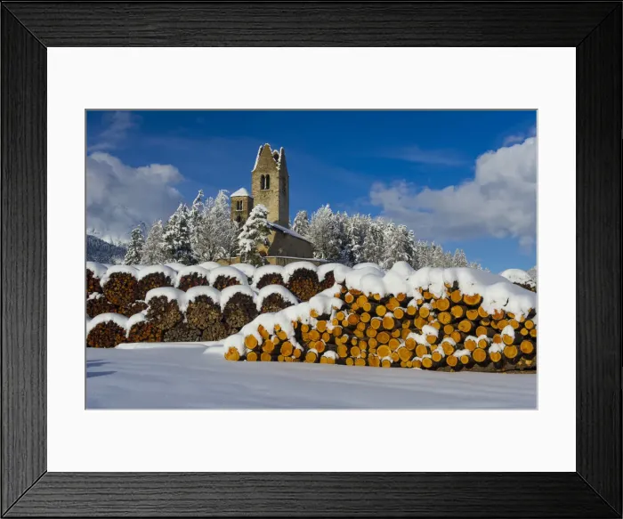 Framed Print : Trunks and old church in Celerina with pristine snow. Engadine, Switzerland, Europe