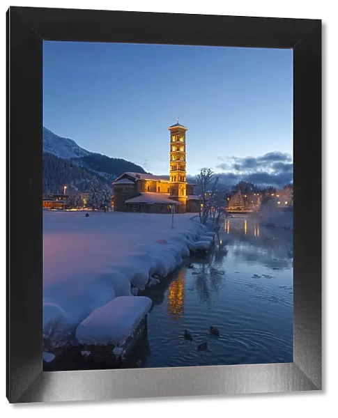 St. Moritz church lights at dusk with pristine snow. Engadine, Switzerland, Europe
