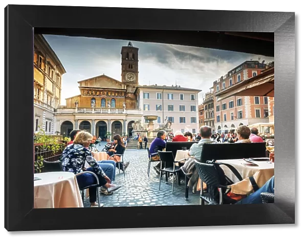 Italy, Rome, tourists having lunch in a restaurant in front of Santa Maria in Trastevere