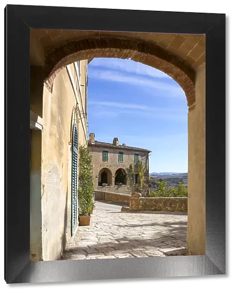 A stone house framed by an arch in the village of Lucignano d Asso, Val