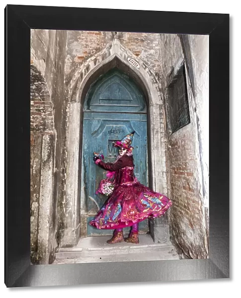 Woman in costume at blue door during Venice Carnival, Venice, Veneto, Italy
