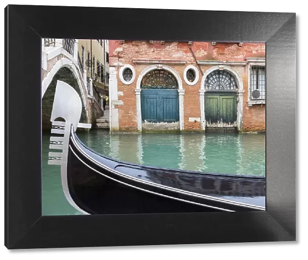 Gondola passes two old doors on canal, Venice, Veneto, Italy