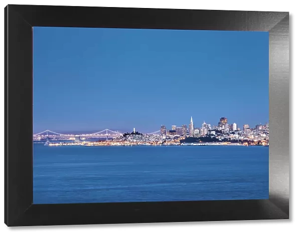 View towards illuminated skyline and bay bridge, San Francisco, California, USA