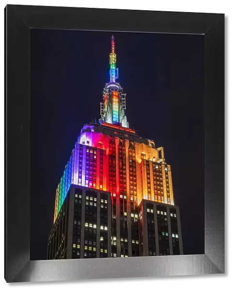 Night low angle view of the Empire State Building with rainbow colors, Manhattan