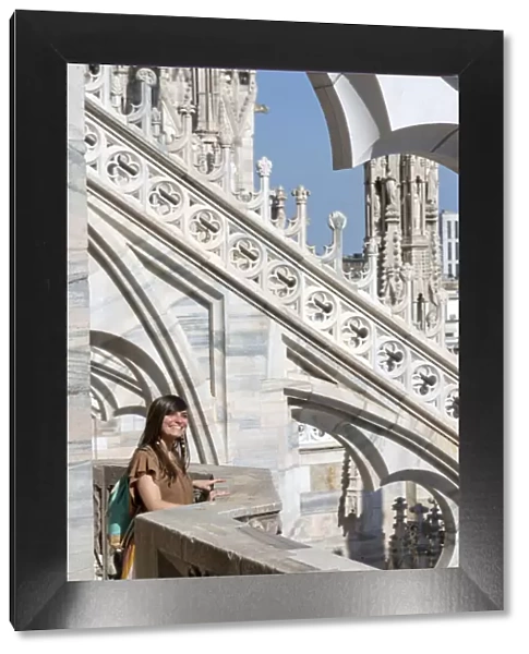 Girl smiling near spires of Milan Cathedral, Lombardy, Italy