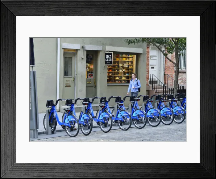 Framed Print : Pedestrian walking past a rack of Citi Bikes on Spring street, in Soho, Manhattan Framed Print : Pedestrian walking past a rack of Citi Bikes on Spring street, in Soho, Manhattan