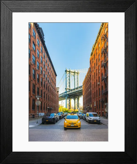 Framed Print : Taxi passing under the Manhattan bridge with the Empire state building framed in