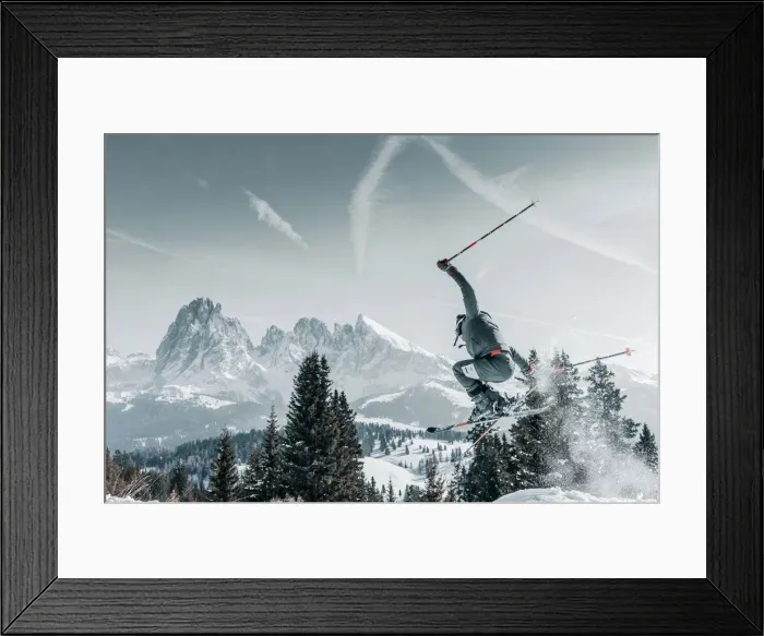 Framed Print : A skier jumping and raising snow with the Sassolungo in the background in the Alpe Framed Print : A skier jumping and raising snow with the Sassolungo in the background in the Alpe