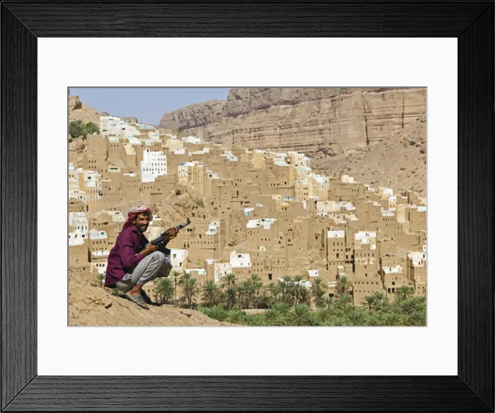 Framed Print : Yemen, Hadhramaut, Wadi Do an, Ribat Ba-Ashan. A happy Yemeni man holds his AK-47 Framed Print : Yemen, Hadhramaut, Wadi Do an, Ribat Ba-Ashan. A happy Yemeni man holds his AK-47