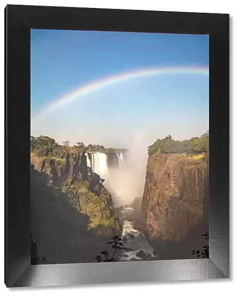Victoria Falls, Zimbabwe, Africa. Rainbow and water steam