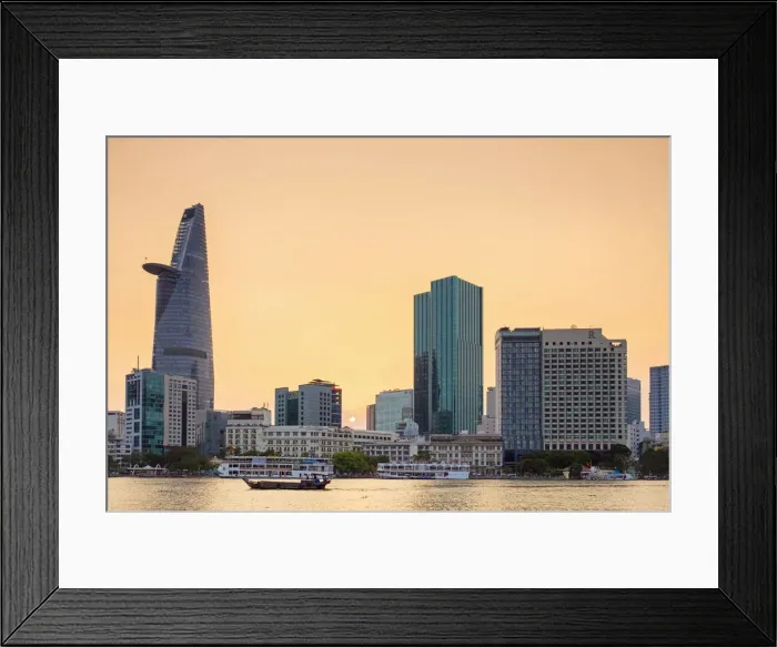 Framed Print : A boat passes by central Ho Chi Minh City (Saigon) skyline on the Saigon River at sunset Framed Print : A boat passes by central Ho Chi Minh City (Saigon) skyline on the Saigon River at sunset