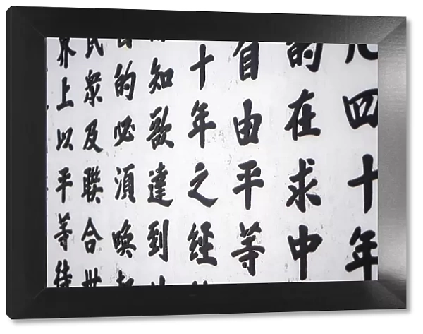 Chinese characters painted on a white wall at a buddhist temple in Hoi An, Quang Nam