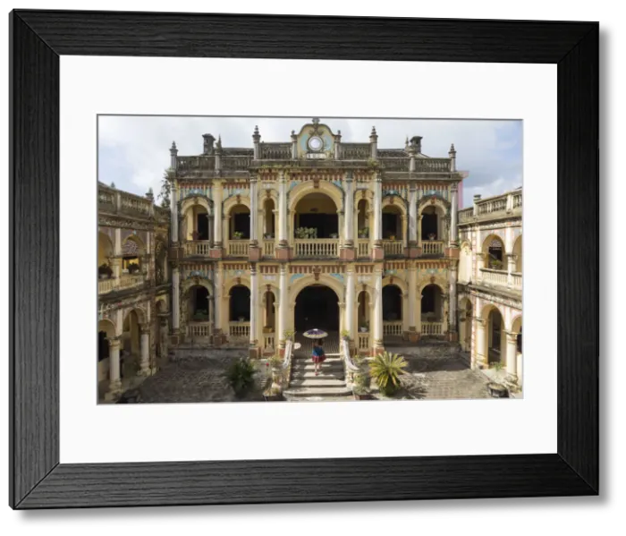 Framed Print : A woman carrying an umbrella walks into the Hoang A Tuong ancient palace in Bac Ha
