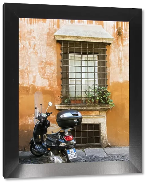 Italian Vespa scooter parked in a cobblestone street of Rome, Lazio, Italy