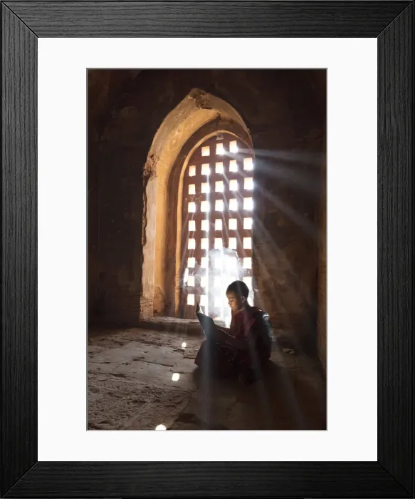 Framed Print : Young Buddhist monk reads by a window in a temple in Bagan, Myanmar Framed Print : Young Buddhist monk reads by a window in a temple in Bagan, Myanmar