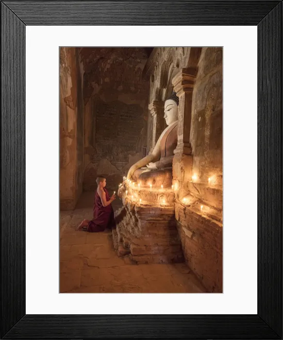 Framed Print : Young Buddhist monk prays in front of a statue of Buddha in a temple in Bagan, Myanmar Framed Print : Young Buddhist monk prays in front of a statue of Buddha in a temple in Bagan, Myanmar