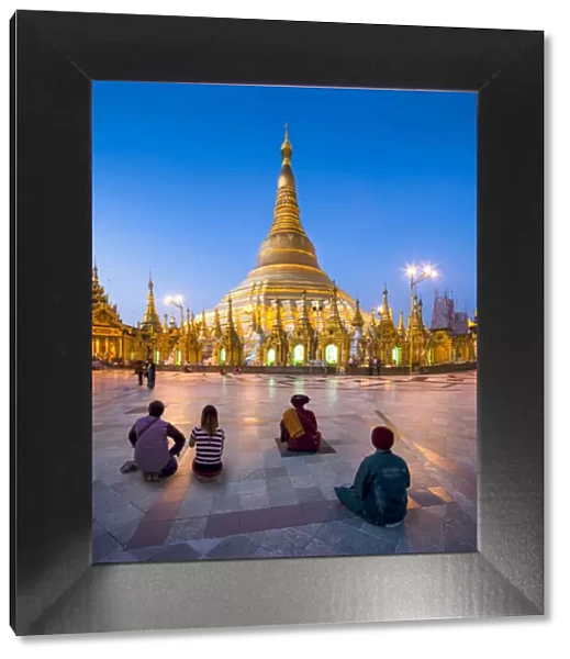 Tourists praying at the Shwedagon Pagoda in Yangon, Yangon Region, Myanmar