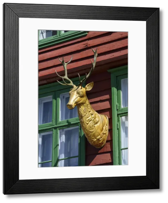 Framed Print : Wooden statue of a deer on a house facade Framed Print : Wooden statue of a deer on a house facade
