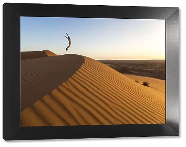 Oman, Wahiba Sands. Tourist jumping on the sand dunes (MR)