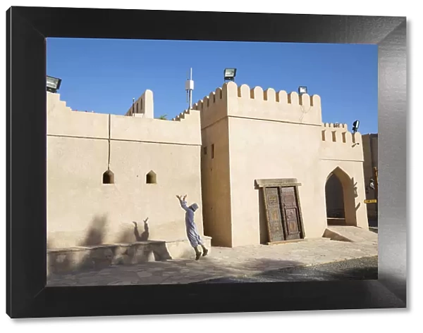 An Omani boy jumps to catch a ball in Bahla Fort, Tanuf, Oman