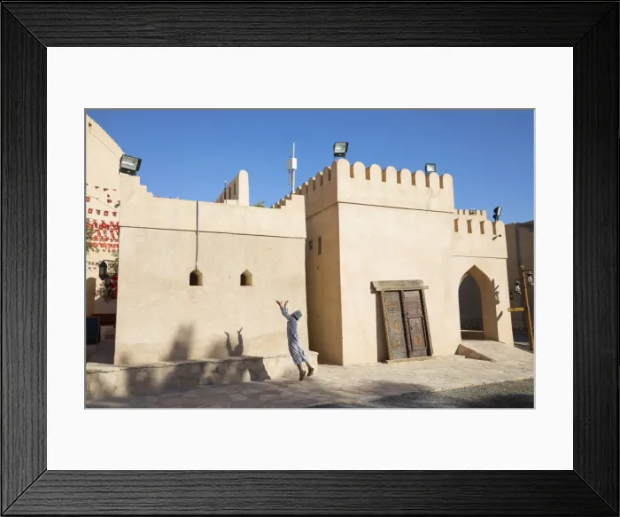 Framed Print : An Omani boy jumps to catch a ball in Bahla Fort, Tanuf, Oman