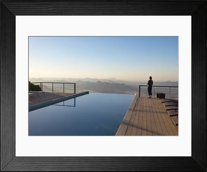 Framed Print : A tourist looks out at the view from the swimming pool at The View hotel, Al Hamra, Oman Framed Print : A tourist looks out at the view from the swimming pool at The View hotel, Al Hamra, Oman