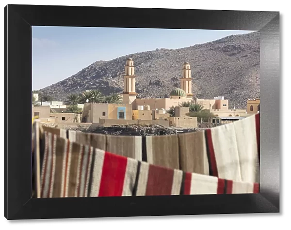 A mosque with carpets hanging in the foreground, Nizwa, Oman