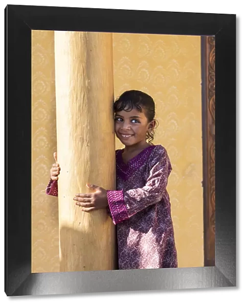 Middle East, Oman, Wahiba sands, a smiley bedouin girl wearing a pretty dress
