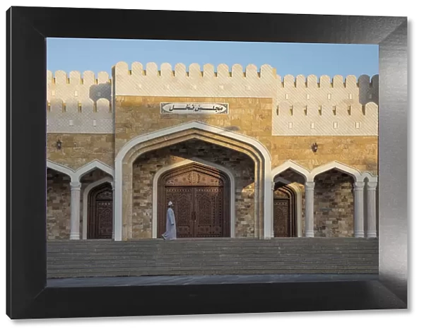 An Omani man walks in front of an ornate house in the village of Nakhal, Al-Batinah