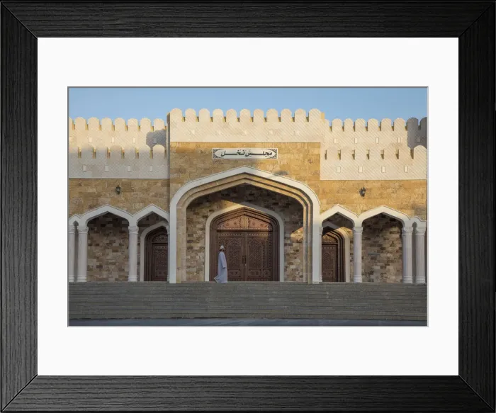 Framed Print : An Omani man walks in front of an ornate house in the village of Nakhal, Al-Batinah Framed Print : An Omani man walks in front of an ornate house in the village of Nakhal, Al-Batinah