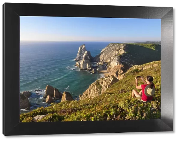 Portugal, Estramadura, Ursa woman sitting on cliff edge (MR)