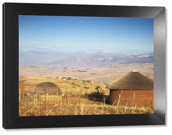 Village huts with Cathedral Peak in background, Ukhahlamba-Drakensberg Park, KwaZulu-Natal