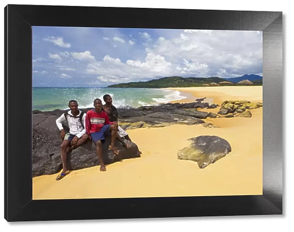 Africa, Sierra Leone, Freetown Peninsula, John Obey Beach. Boys sitting on rocks
