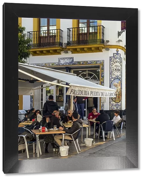 Tourists seated at tables outside a tapas bar in Seville, Andalusia, Spain