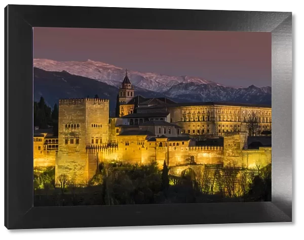View at dusk of Alhambra palace with the snowy Sierra Nevada in the background, Granada