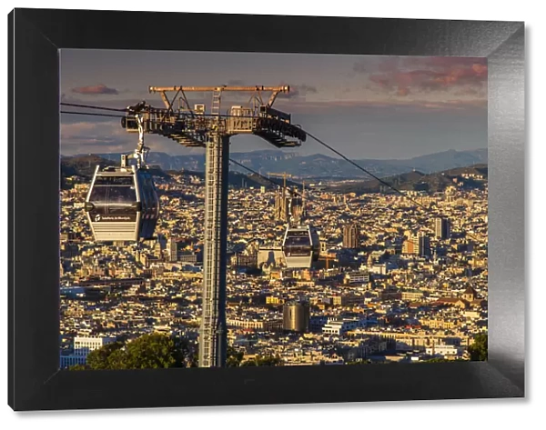 Teleferic de Montjuic or aerial tramway with city skyline at sunset, Barcelona, Catalonia