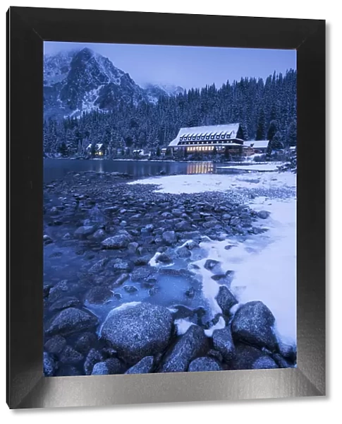 Frozen lake shore and Mountain House at twilight, Popradske Pleso, High Tatras, Slovakia