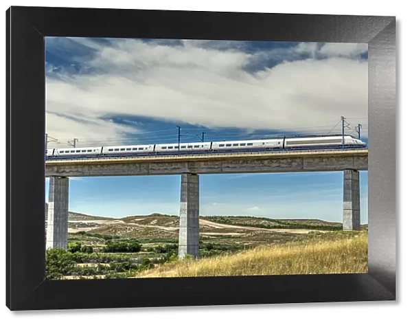 The Madrid-Barcelona AVE high-speed passenger train while is crossing a viaduct, Fuentes