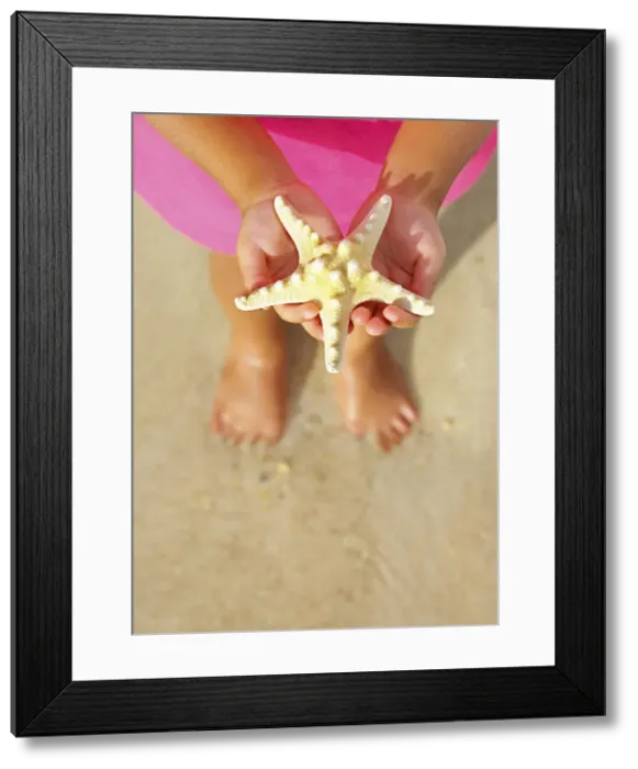 Framed Print : Trinidad and Tobago, Tobago Island, Pigeon Point, Child holding starfish over sand (MR) Framed Print : Trinidad and Tobago, Tobago Island, Pigeon Point, Child holding starfish over sand (MR)