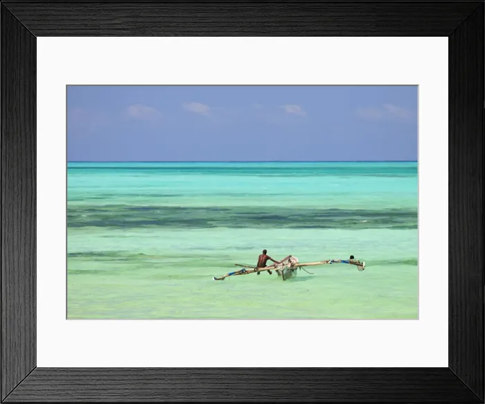Framed Print : Tanzania, Zanzibar, Unguja, Jambiani. A man sits on his boat near the shore Framed Print : Tanzania, Zanzibar, Unguja, Jambiani. A man sits on his boat near the shore